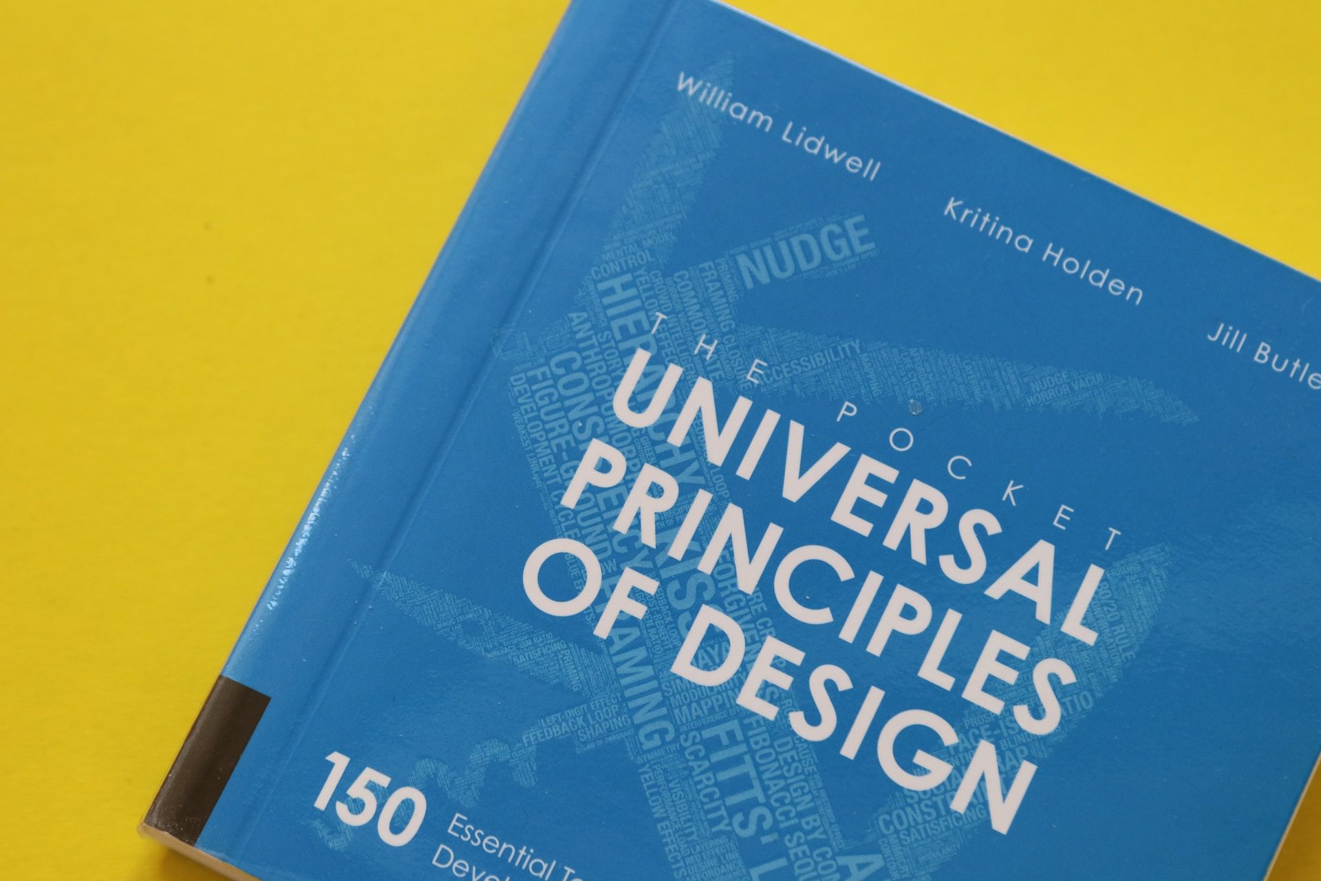 A blue design book on a yellow background